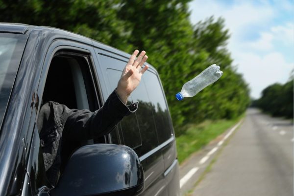 a person throwing a bottle from a car window